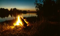 A beautiful sunrise by the river, a campfire, and birds singing