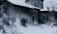 An isolated, medieval prison in a snowy setting