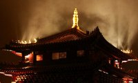 Praying in the monastery beside lit torches on a windy night.