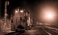 Rain in a small town at night, with a train passing through