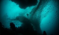 A diver breathing as they travel through deep water